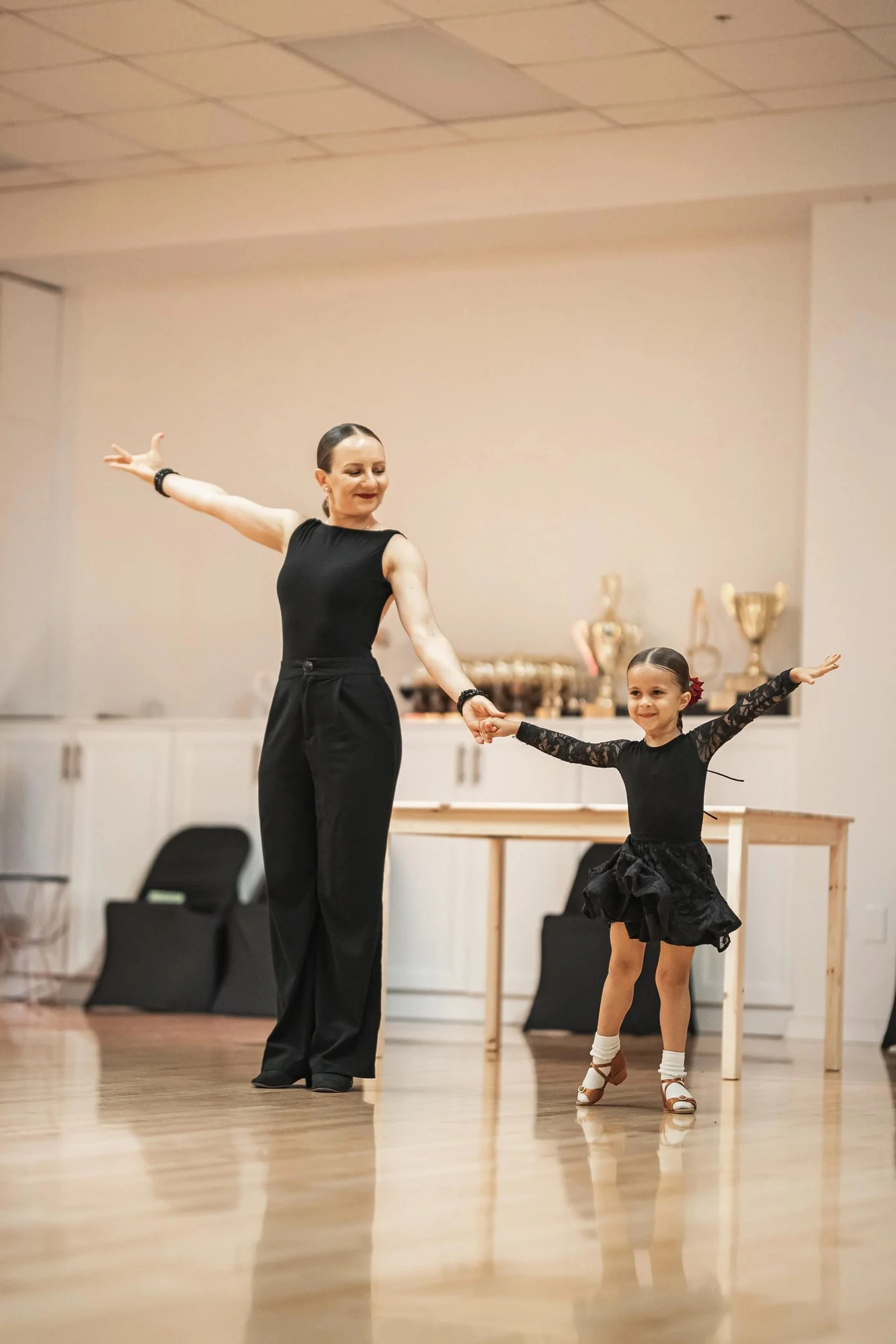 A young dancer working on posture with a patient instructor at S-Style Dance Team
