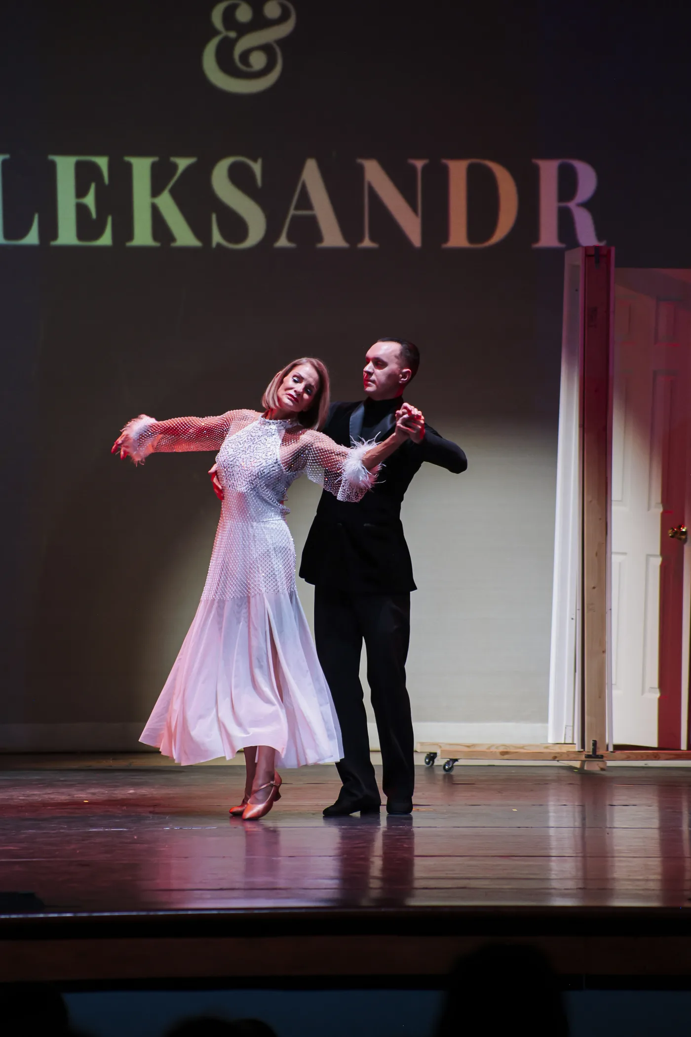 A couple performing a ballroom routine on stage at an S-Style Dance Team showcase